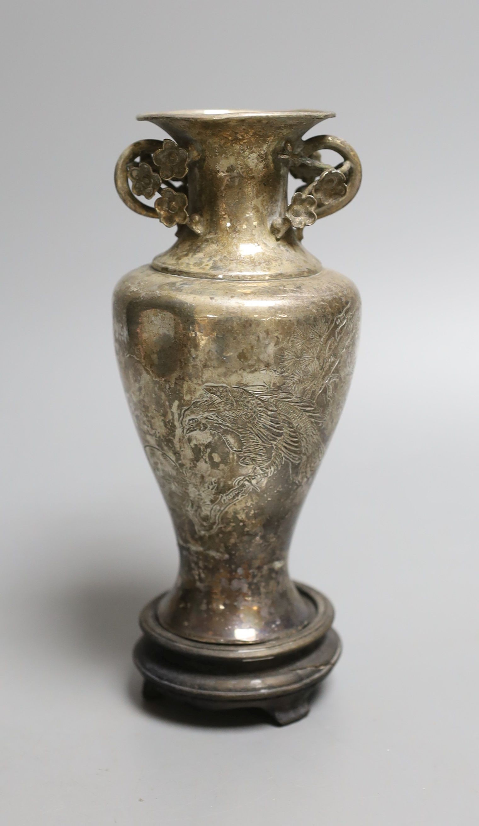 An early 20th century Chines engraved white metal two handled vase, on a wooden stand, vase 13.5cm.